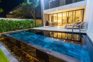 a swimming pool in the backyard of a house at Faru Beachfront Villa Sanctuary Ho Tram in Ho Tram