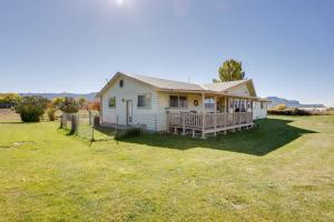 a white house with a large yard with a house at Cortez Retreat with Office and Stunning Mtn Views in Cortez