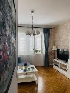 a living room with a table and a tv at Luxury apartment Lukas in Orebić