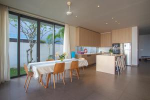 a kitchen and dining room with a table and chairs at Faru Beachfront Villa Sanctuary Ho Tram in Ho Tram