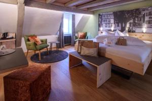 a hotel room with a large bed and a chair at Hotel Herrmann in Münsingen +38 photos