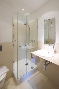 a bathroom with a shower and a sink and a toilet at Hotel Staffler in Odelzhausen