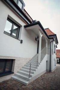 a white house with stairs and windows at Lumen Gasztropanzió in Eger