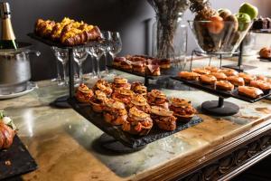 a buffet with several trays of pastries and other desserts at Hotel Atari in Donostia-San Sebastián