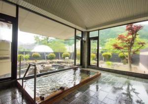 a large room with a pool of water with a large window at glampark Akasawa Onsen Tochigi in Nasushiobara