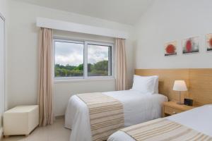um quarto de hotel com duas camas e uma janela em Vilar do Golf na Quinta do Lago