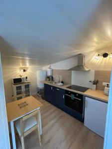 a large kitchen with a stove and a table at Maison MAHECO in Gujan-Mestras
