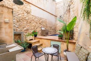 a patio with a table and chairs and a sink at Casa Romana in Pollença