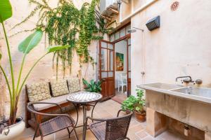 a patio with a table and chairs and a sink at Casa Romana in Pollença
