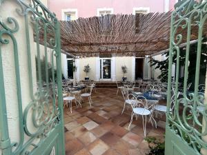 una puerta abierta con mesas y sillas en un patio en Le patio de Fabio, en Bollène