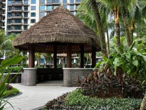 新山Central Park, Tampoi by Antlerzone的一个带草伞和棕榈树的凉亭