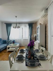 a dining room with a table and a living room at Luxury apartment Lukas in Orebić