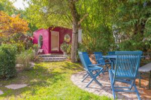 - une table de pique-nique et des chaises devant une maison rose dans l'établissement DOMIZIL VIA CLAUDIA, 