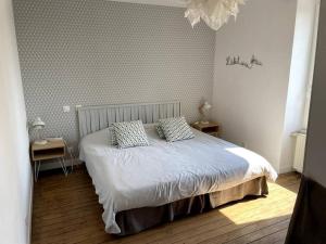 ein Schlafzimmer mit einem Bett mit zwei Kissen darauf in der Unterkunft Superbe gîte pour 15 personnes in Le Ménil-Brout
