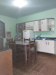 a kitchen with a table and chairs in a room at Praiana in Guaratuba