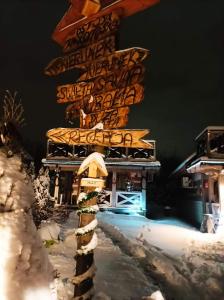 un panneau dans la neige devant un bâtiment dans l'établissement Ostoja Karkonoska, à Podgórzyn