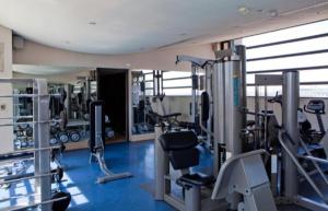 einen Fitnessraum mit mehreren Laufbändern und Maschinen in der Unterkunft Luxurious apartments in Johannesburg