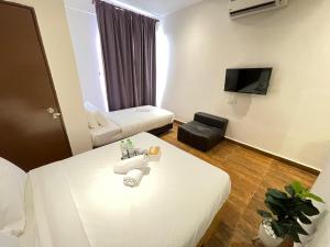 Cette petite chambre comprend un lit et un canapé. dans l'établissement Swing & Pillows - KL Sri Petaling, à Kuala Lumpur