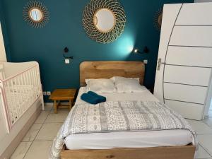 Schlafzimmer mit einem Bett mit blauer Wand in der Unterkunft Villa 3 grandes chambres . in Sainte-Anne
