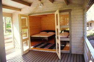 a small wooden house with a bedroom and a bed at Valgeranna Puhkekeskus in Valgeranna +38 photos