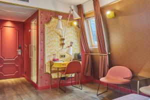 a room with a table and two chairs and a mirror at Idol Hotel in Paris