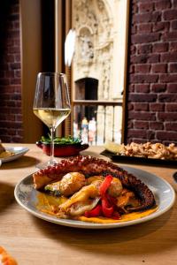 a plate of food on a table with a glass of wine at Hotel Atari in Donostia-San Sebastián