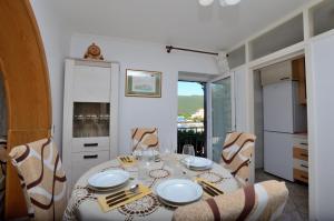 a dining room with a table and chairs and a kitchen at App Lori in Rabac