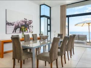 een eetkamer met een tafel en stoelen bij CapeStays - Villa Infinity in Kaapstad