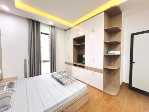 1 dormitorio blanco con 1 cama y techo amarillo en KenPi Homestay - ở đường hoa Bằng Lăng, en Hue