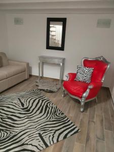 a living room with a red chair and a zebra rug at Mariposa in Capodimonte