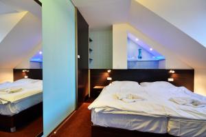a hotel room with two beds and a mirror at Wellness Penzion Kroměříž - Zlobice in Kroměříž