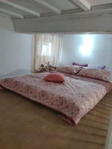 a bed with pink sheets and pillows on it at Mariposa in Capodimonte