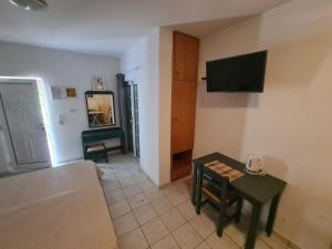 a living room with a couch and a table and a television at Cost Mari Almyrida New by ZAGO Boutiqe hotels in Almyrida