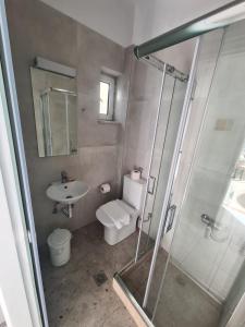y baño con ducha, aseo y lavamanos. en Cost Mari Almyrida New by ZAGO Boutiqe hotels, en Almyrida