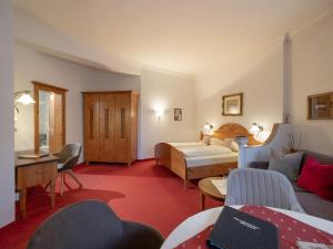 um quarto de hotel com uma cama e um sofá em Ferienhaus Willms am Gaisberg em Kirchberg in Tirol