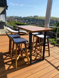 a wooden table and chairs on a deck at Lina's Ferienwohnungen - zwei moderne FeWos mit Sauna im Haus und fantastischem Ausblick in Sankt Andreasberg