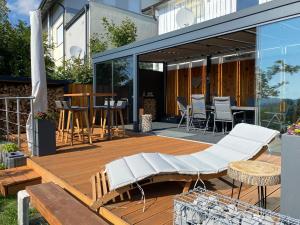 een houten terras met een bank en een tafel bij Lina's Ferienwohnungen - zwei moderne FeWos mit Sauna im Haus und fantastischem Ausblick in Sankt Andreasberg