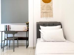 a bedroom with a bed and a desk with a chair at Greenfield Residence Bandar Sunway in Petaling Jaya