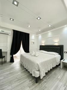 a white bedroom with a large bed and a window at Locanda Parlamento in Rome