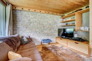 a living room with a couch and a tv at Le Jangilau in Morzine