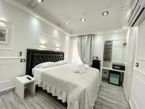 a white bedroom with a bed and a desk at Locanda Parlamento in Rome