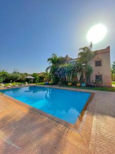 une grande piscine en face d'une maison dans l'établissement villa atika, à Marrakech
