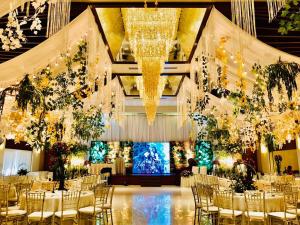 a banquet hall with tables and chairs and chandeliers at Sugarland Hotel in Bacolod