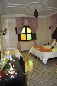 - une chambre avec 2 lits et une table fleurie dans l'établissement villa atika, à Marrakech