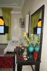 - une chambre avec un lit et une table avec un miroir dans l'établissement villa atika, à Marrakech