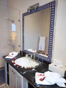 La salle de bains est pourvue d'un lavabo et d'un grand miroir. dans l'établissement villa atika, à Marrakech