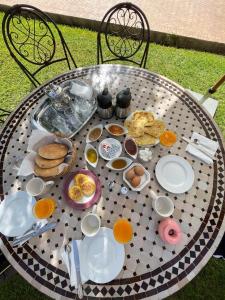 une table avec des assiettes de nourriture au-dessus dans l'établissement villa atika, à Marrakech