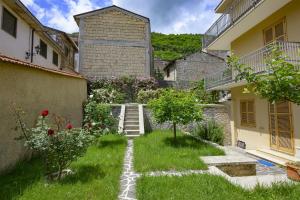 a garden with stairs and flowers in front of a building at Orsini: tre camere da letto, 2 bagni in Luco neʼ Marsi