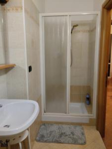 uma casa de banho com um chuveiro e um lavatório. em Montenero House em Bolonha