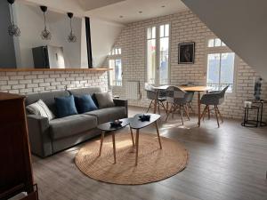 a living room with a couch and a table at Les toits d'Albatre in Dieppe